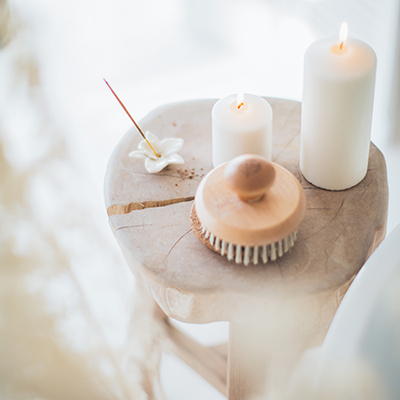 Long white candles and brushes on a wooden round stool